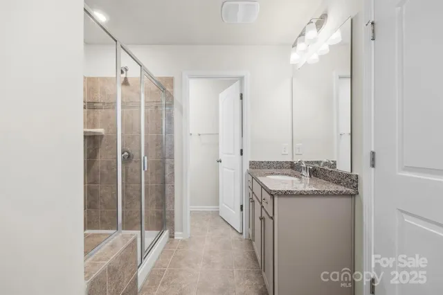 a bathroom with a granite countertop sink a mirror and a shower