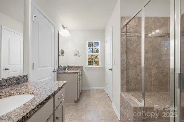 a bathroom with a granite countertop sink a mirror and a bathtub