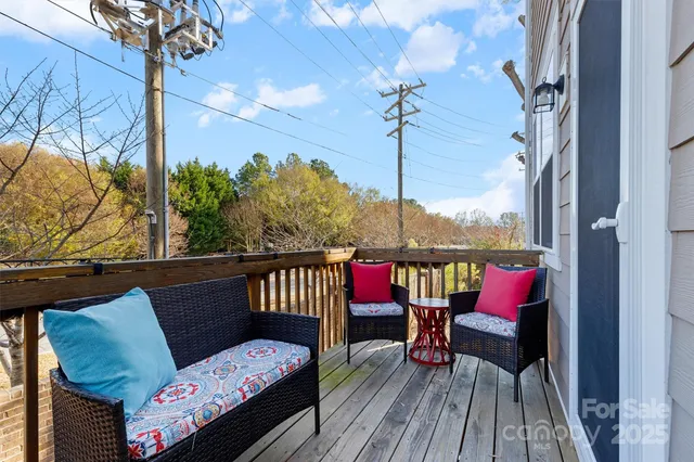 a view of deck with table and chairs potted plants with wooden floor and fence