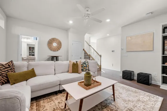 a living room with furniture a rug and wall paintings