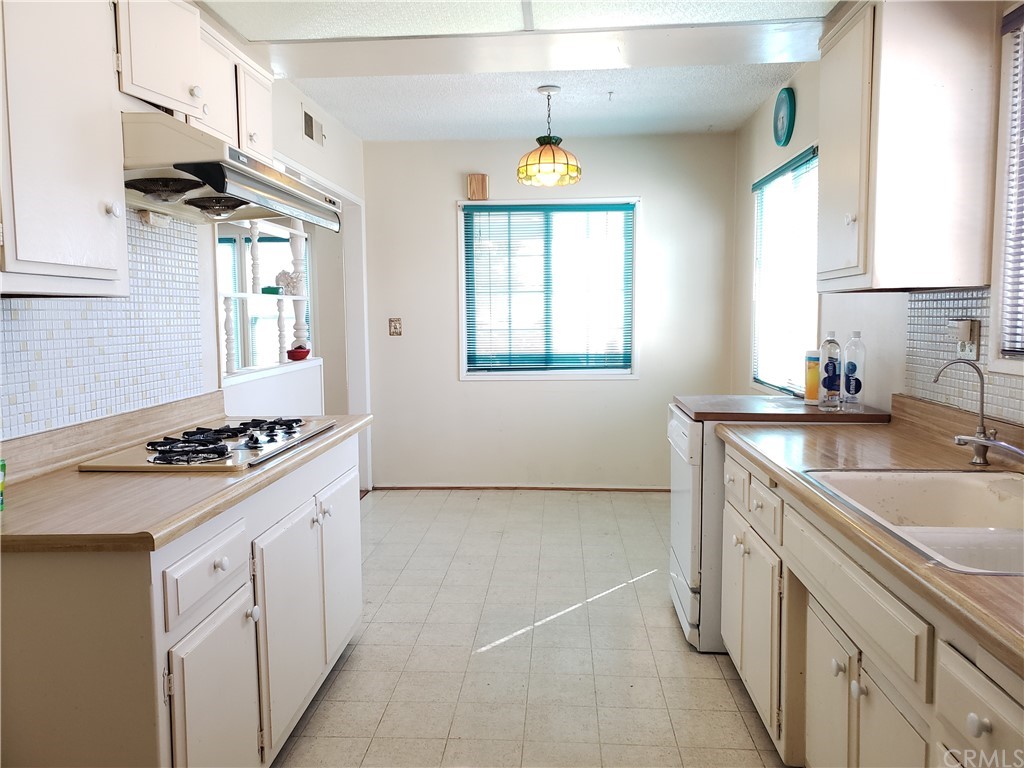 11929 Ranchito Street El Monte, CA 91732 - Photo 5 of 28 a kitchen with a sink stove and cabinets