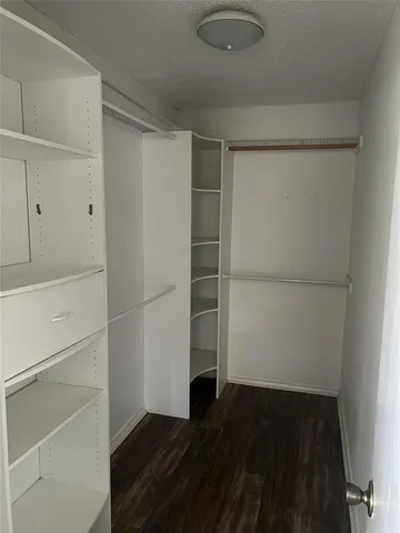 a view of walk in closet with empty racks