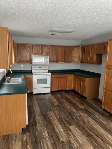 a kitchen with granite countertop a sink and a stove top oven
