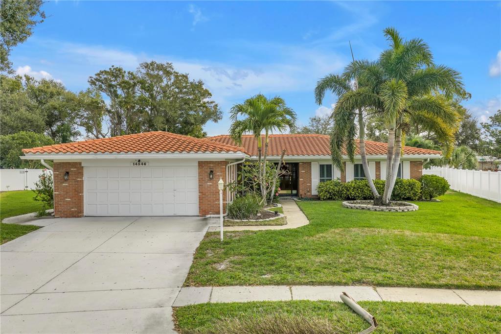 14546 Anchorage Circle Seminole, FL 33776 - Photo 2 of 88 a front view of a house with a yard and garage