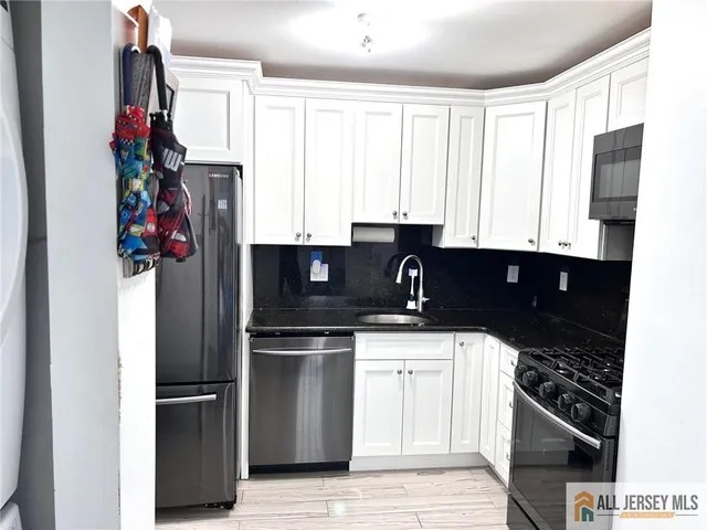 a kitchen with a refrigerator stove and white cabinets