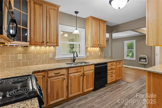 a kitchen with stainless steel appliances granite countertop a stove a sink and a refrigerator