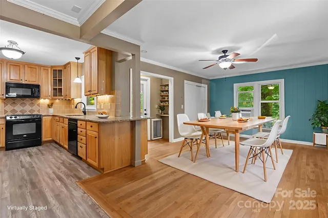 a open kitchen with stainless steel appliances granite countertop a stove top oven a sink dishwasher a dining table and chairs with wooden floor