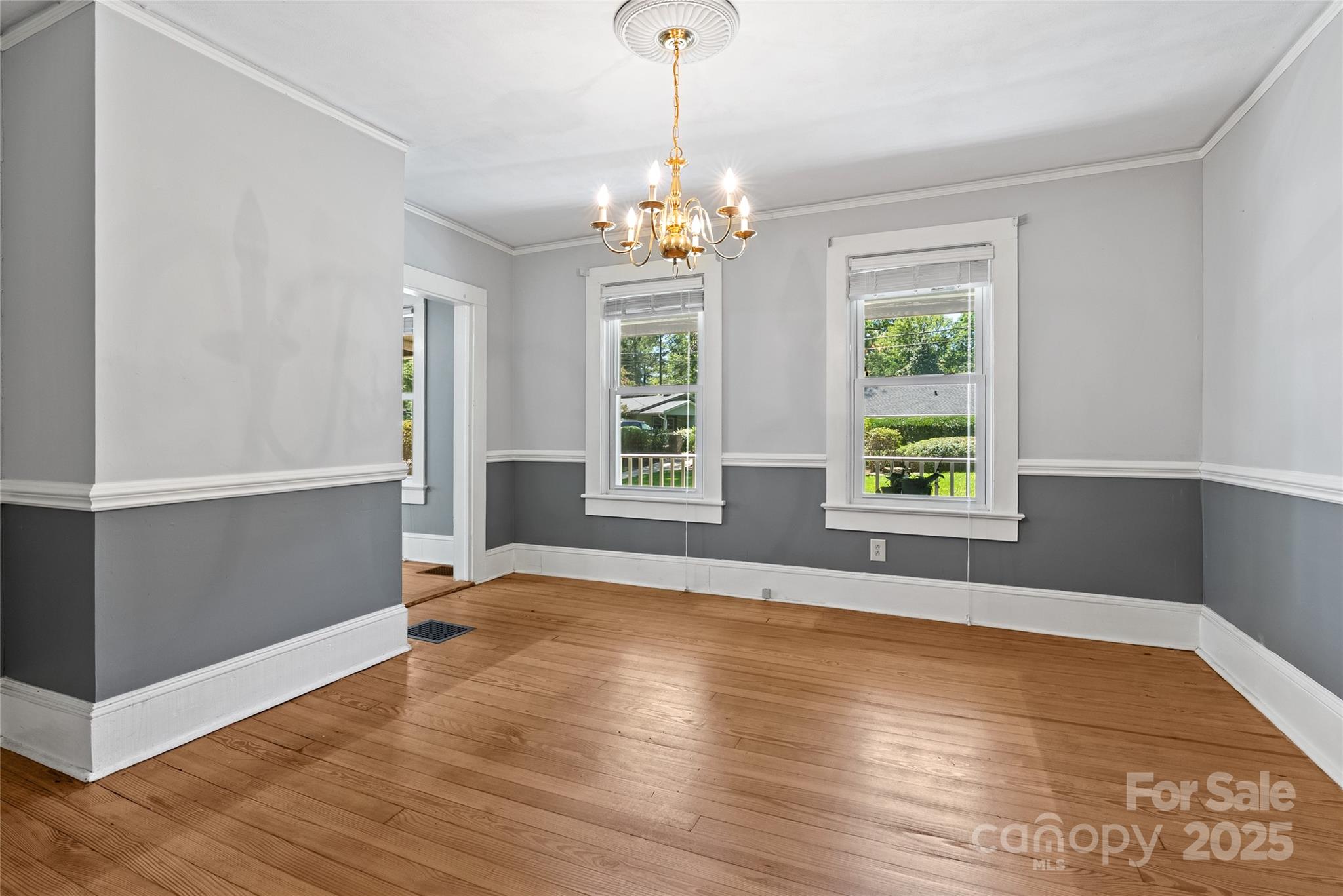 80 Laurel Avenue Tryon, NC 28782 - Photo 20 of 43 an empty room with wooden floor chandelier and windows