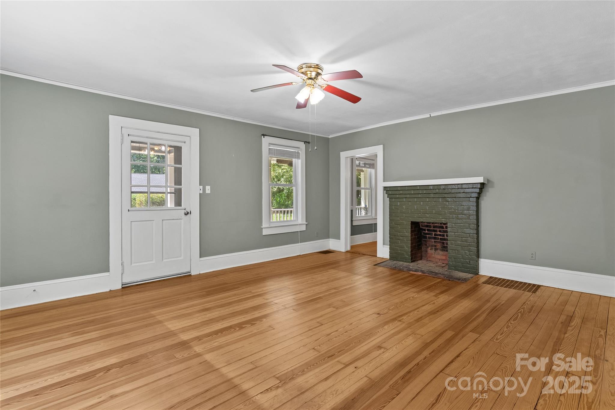 80 Laurel Avenue Tryon, NC 28782 - Photo 8 of 43 a view of an empty room with wooden floor fireplace and a window