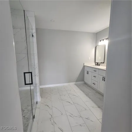 a spacious bathroom with a mirror and shower