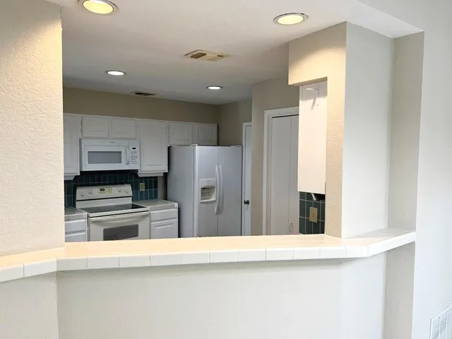a kitchen with refrigerator and cabinets