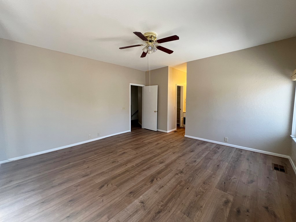 805-139 Highway 534 Loop Kerrville, TX 78028 - Photo 17 of 28 a view of an empty room with wooden floor and a ceiling fan