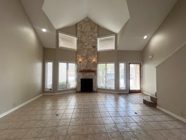 a view of an empty room with a fireplace and a window