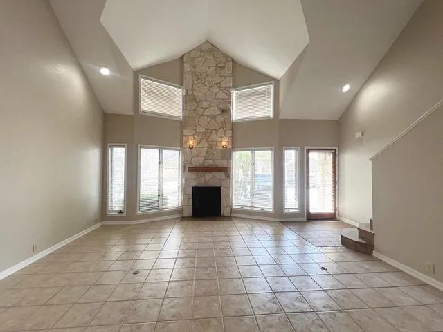 a view of an empty room with a fireplace and a window