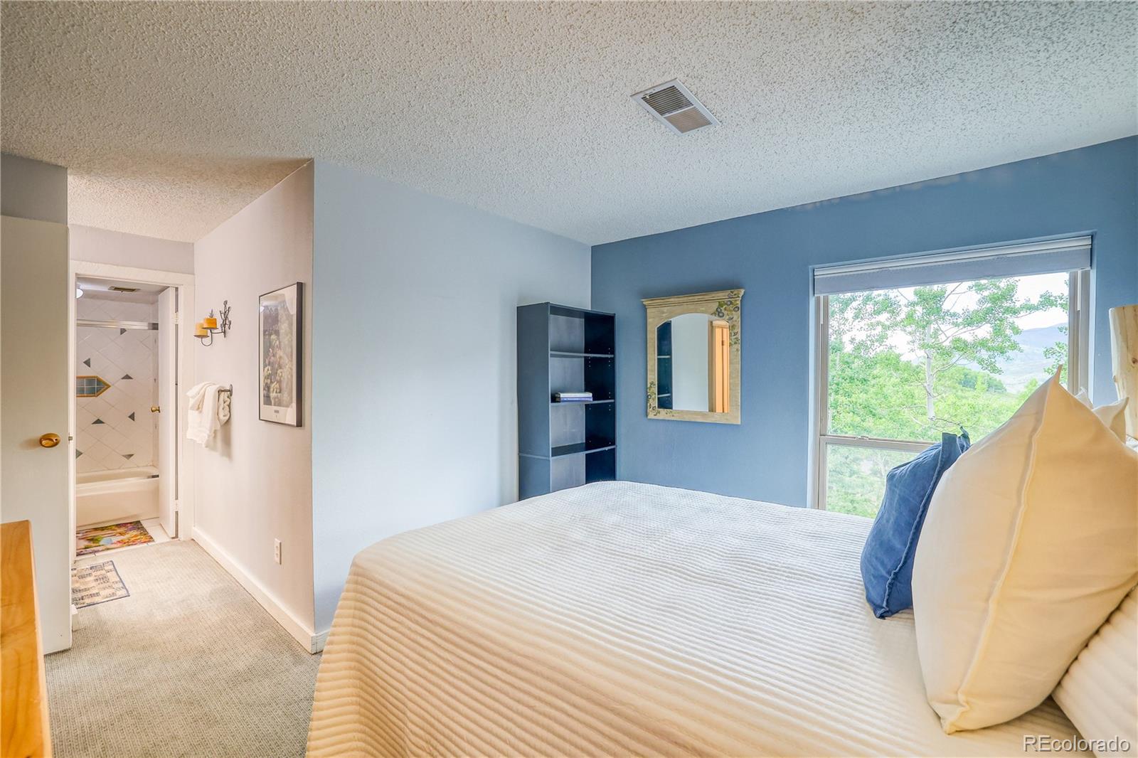 2510 Ryan Gulch Road, Unit 2512 Silverthorne, CO 80498 - Photo 21 of 41 a bedroom with a large bed and a large window