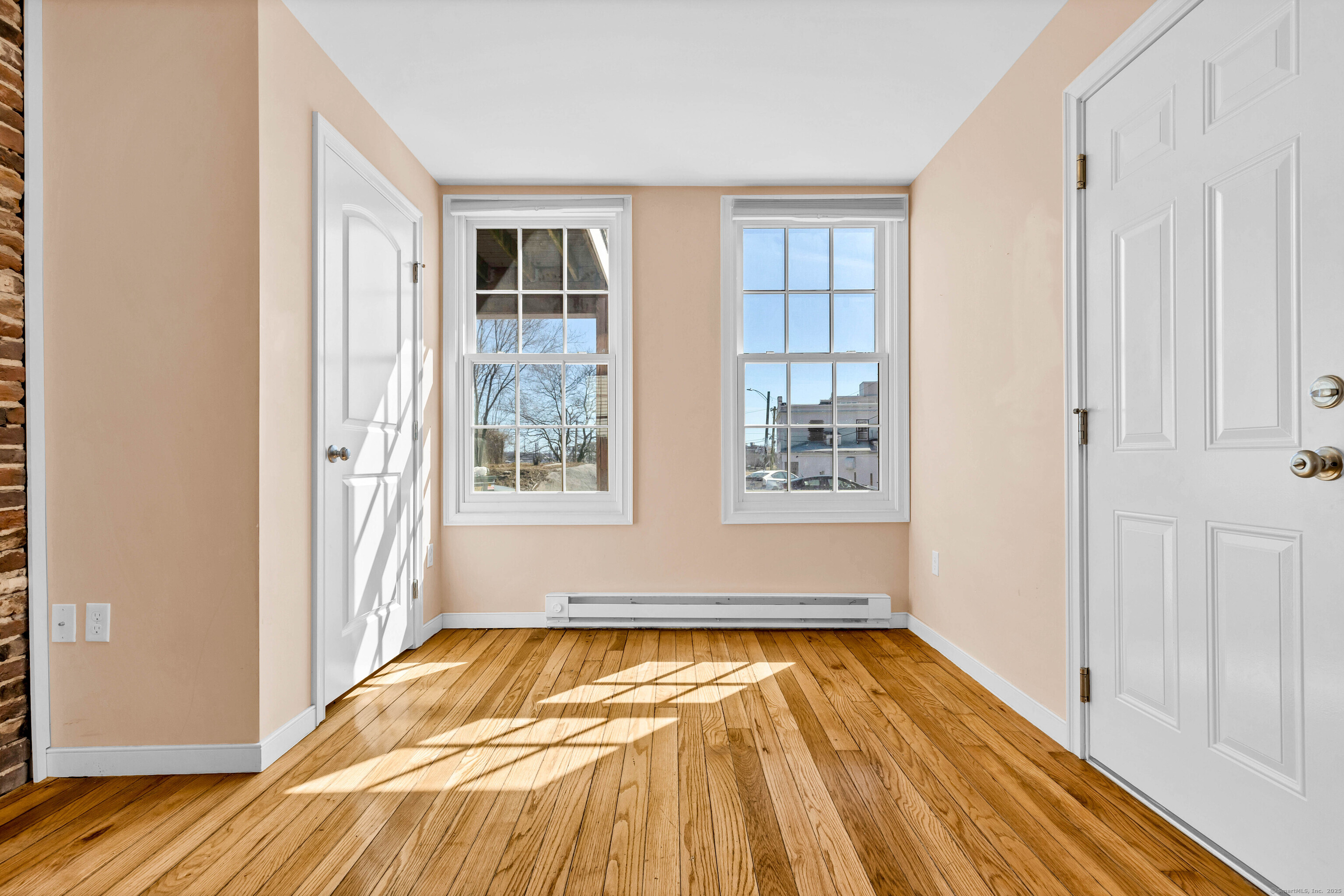 9 Brewer Street New London, CT 06320 - Photo 18 of 40 a view of an empty room with wooden floor and a window