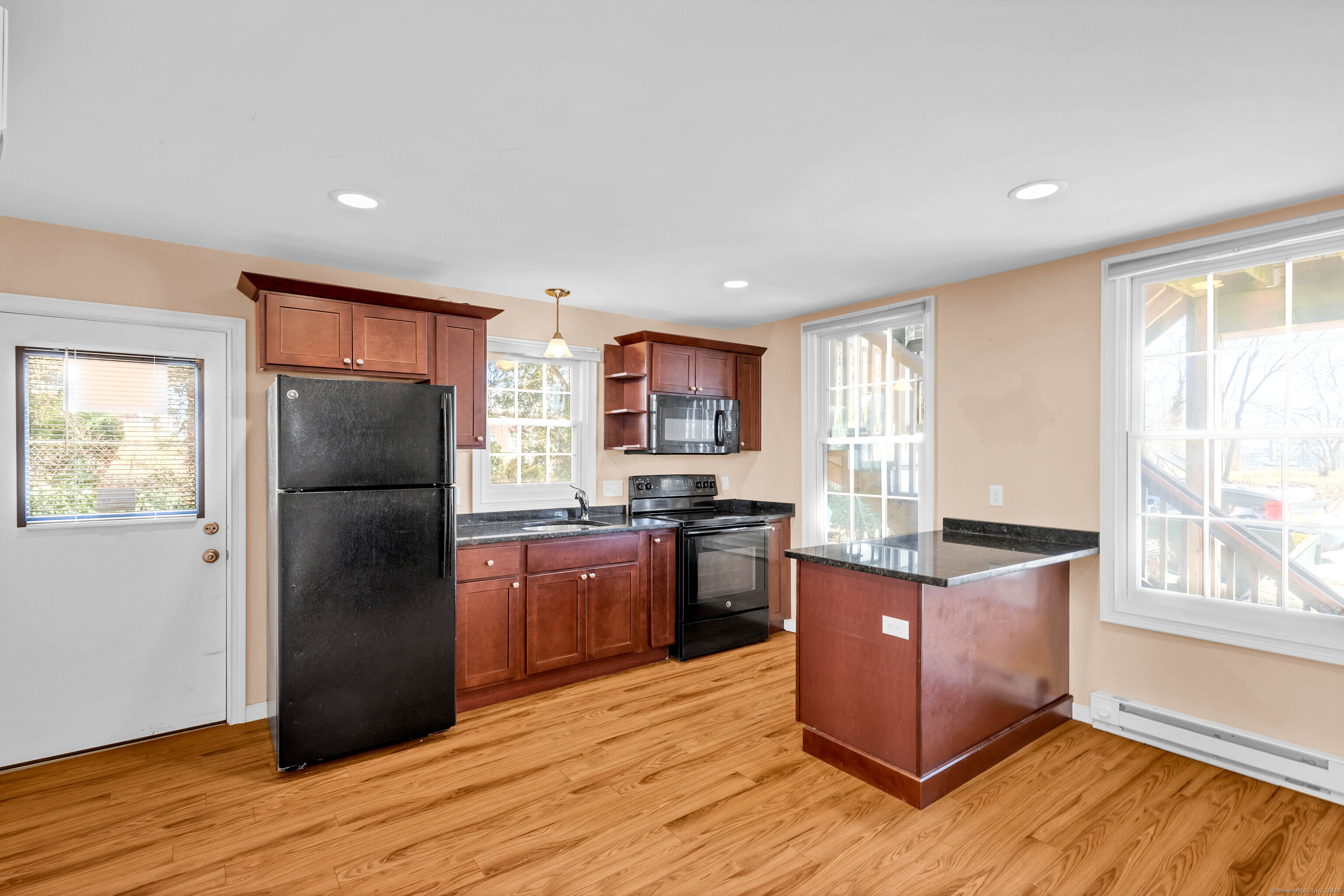 9 Brewer Street New London, CT 06320 - Photo 21 of 40 a kitchen with stainless steel appliances granite countertop a refrigerator stove and wooden floor