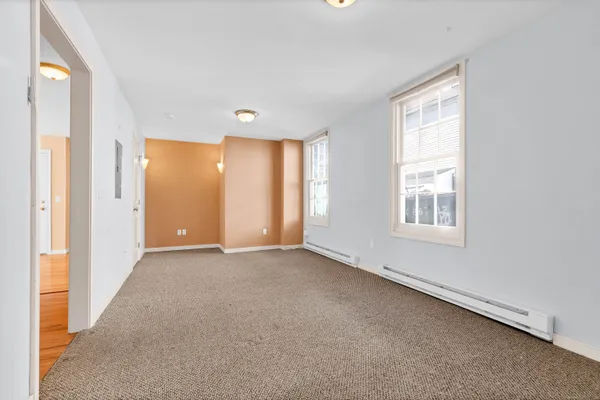 an empty room with windows and closet