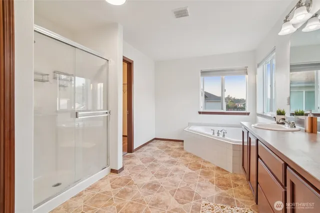 a large bathroom with a tub sink shower and mirror