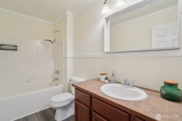 a bathroom with a granite countertop sink toilet a mirror and bathtub