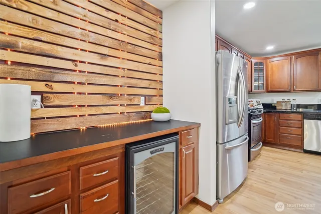a kitchen with stainless steel appliances granite countertop a refrigerator and a stove top oven