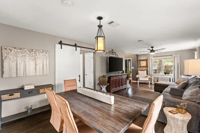 a living room with furniture a flat screen tv and a chandelier
