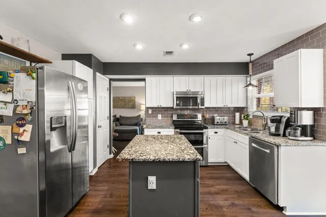 a kitchen with a stove sink and cabinets