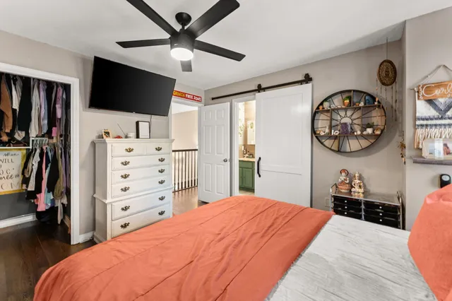 a bedroom with a bed and a flat screen tv on the dresser