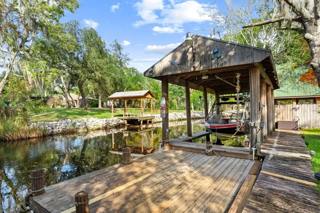 a view of a big yard with table and chairs and potted plants