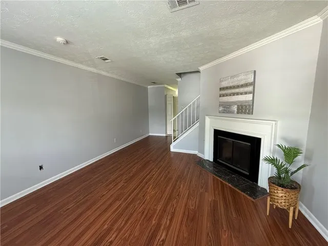 a view of empty room with wooden floor and fireplace