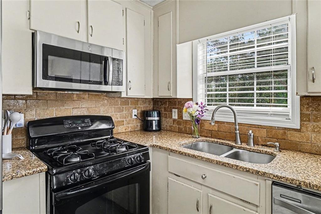 829 Dunes Way Austell, GA 30106 - Photo 11 of 28 a kitchen with granite countertop a stove a sink and a microwave