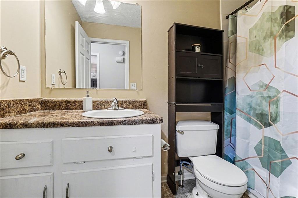 829 Dunes Way Austell, GA 30106 - Photo 14 of 28 a bathroom with a granite countertop toilet sink and mirror