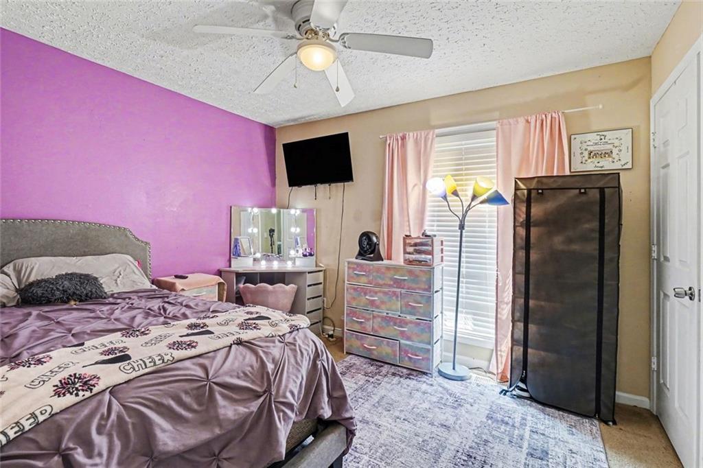 829 Dunes Way Austell, GA 30106 - Photo 16 of 28 a bedroom with a bed dresser and a flat tv screen