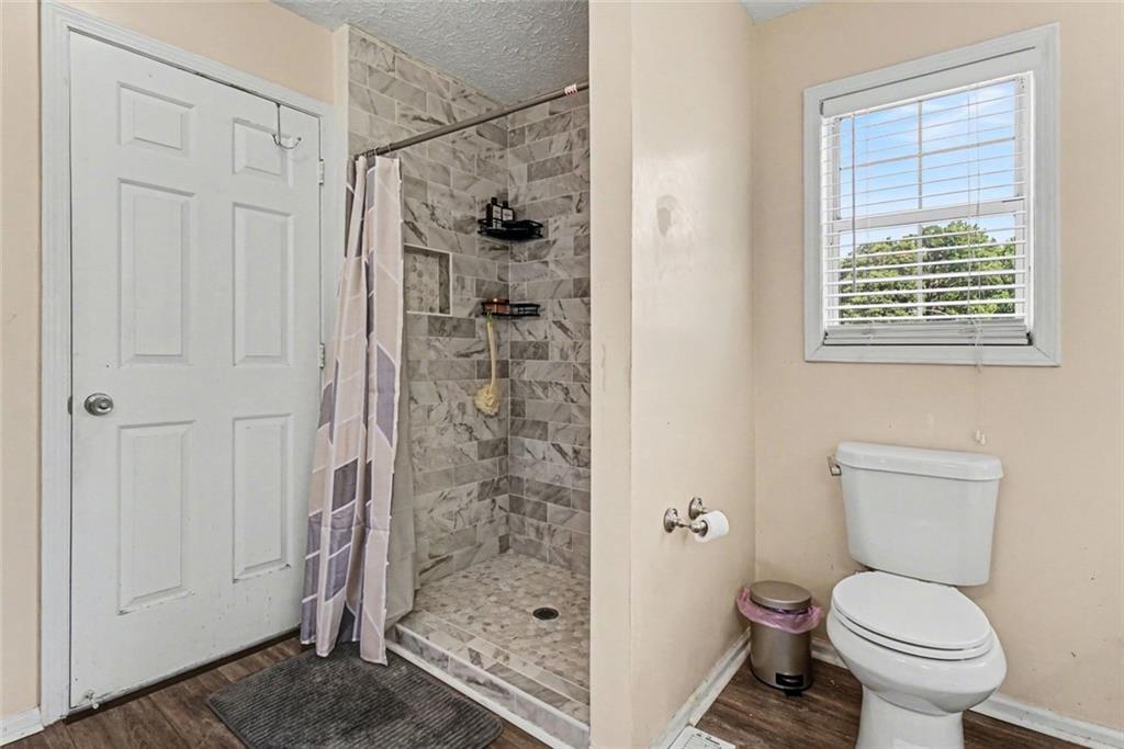 829 Dunes Way Austell, GA 30106 - Photo 20 of 28 a bathroom with a toilet and a shower