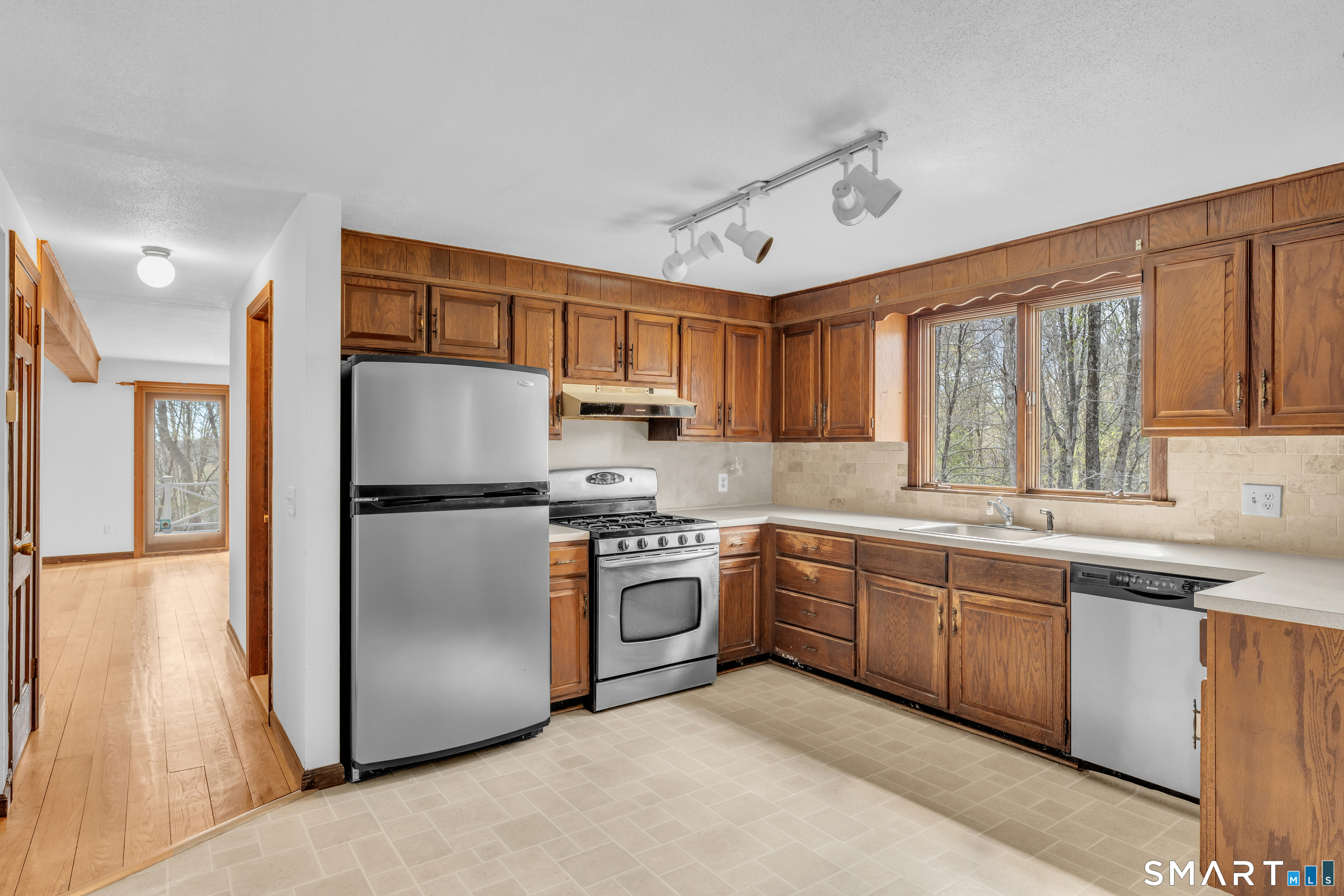 94 Quonnipaug Hill Road Guilford, CT 06437 - Photo 14 of 39 a kitchen with stainless steel appliances granite countertop a refrigerator a sink dishwasher a stove with wooden cabinets and floor