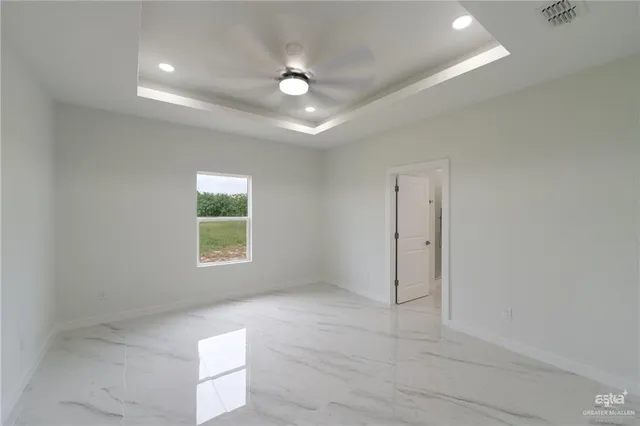 an empty room with a window and a ceiling fan