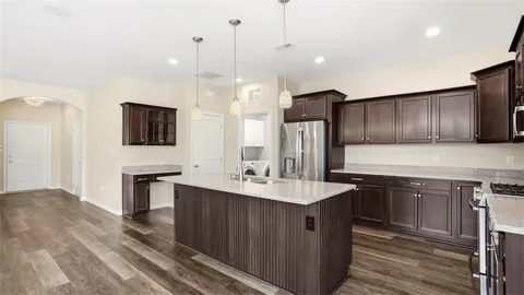 a kitchen with stainless steel appliances granite countertop a sink a stove and a wooden floors