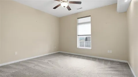 an empty room with a window and a ceiling fan