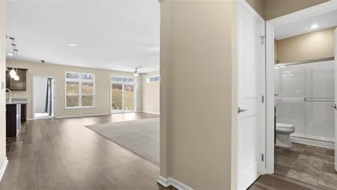 a view of an empty room with glass door and wooden floor