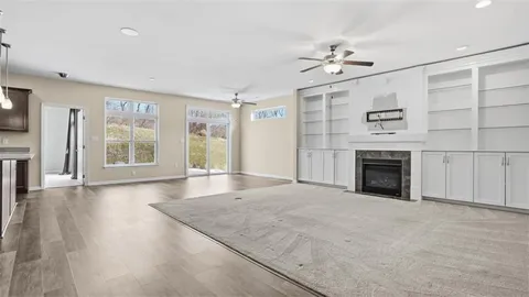 a view of an empty room with a fireplace and a window