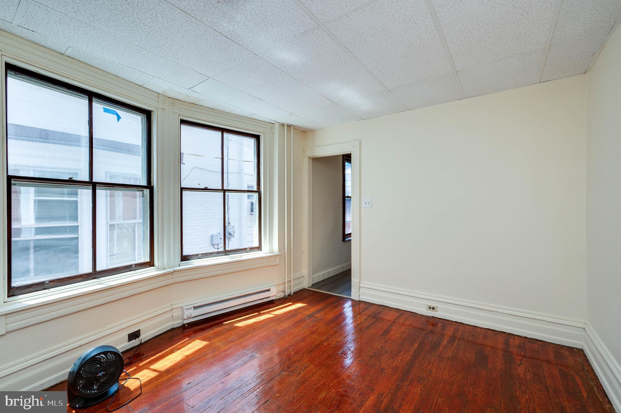 1032 North 5th Street Reading, PA 19601 - Photo 11 of 45 an empty room with wooden floor and windows
