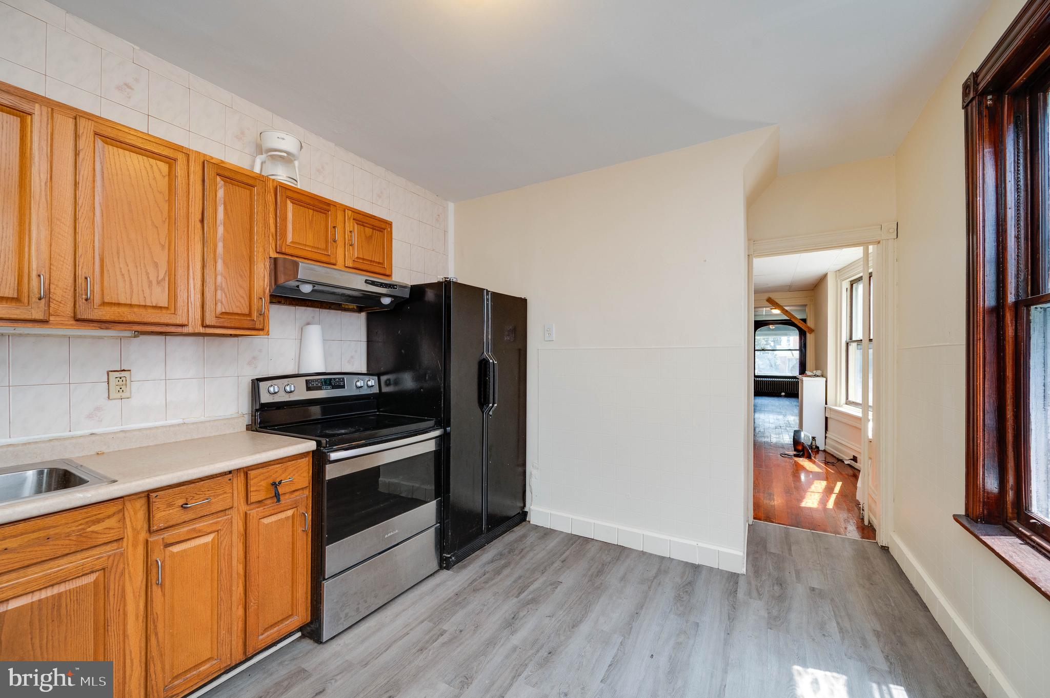 1032 North 5th Street Reading, PA 19601 - Photo 18 of 45 a kitchen with granite countertop wooden floors and stainless steel appliances