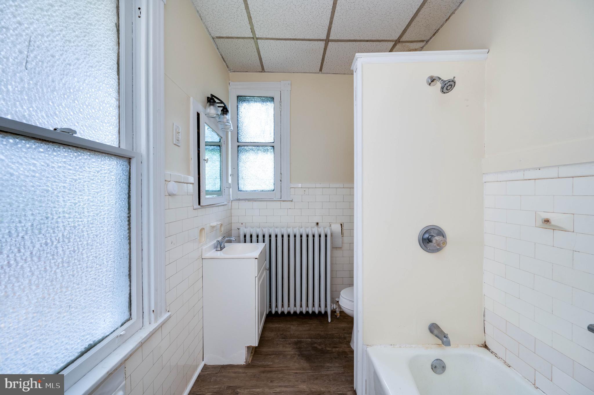 1032 North 5th Street Reading, PA 19601 - Photo 19 of 45 a bathroom with a bathtub a shower a sink and a window