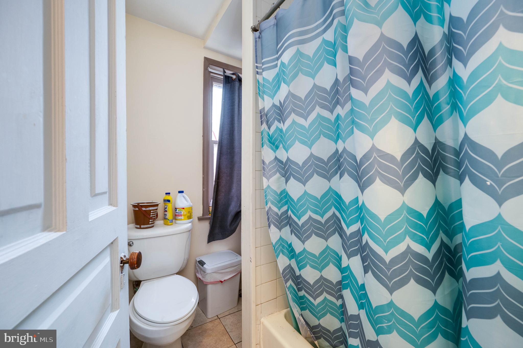 1032 North 5th Street Reading, PA 19601 - Photo 40 of 45 a white toilet sitting next to a shower curtain