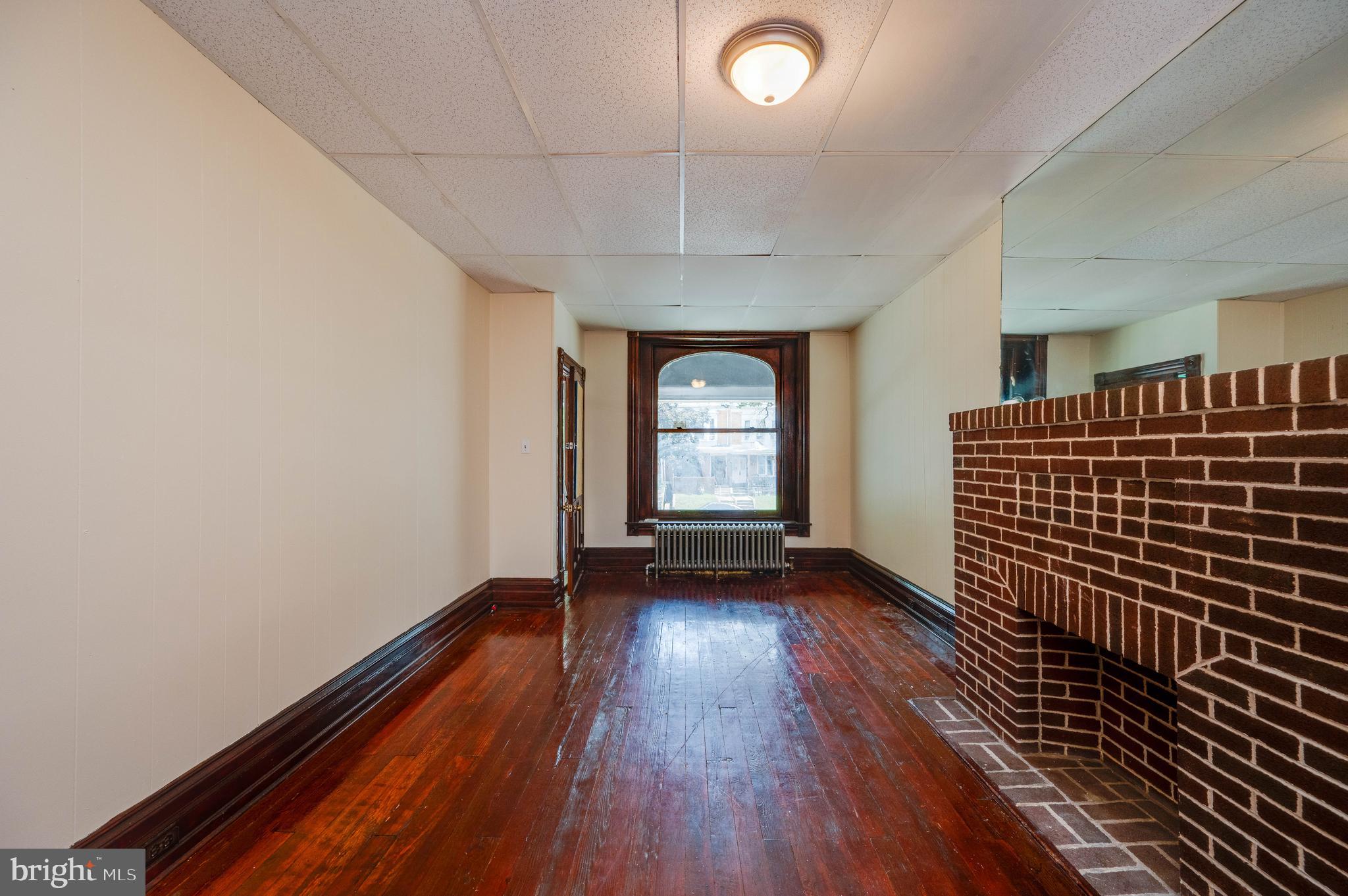 1032 North 5th Street Reading, PA 19601 - Photo 7 of 45 a view of an empty room with wooden floor and a window