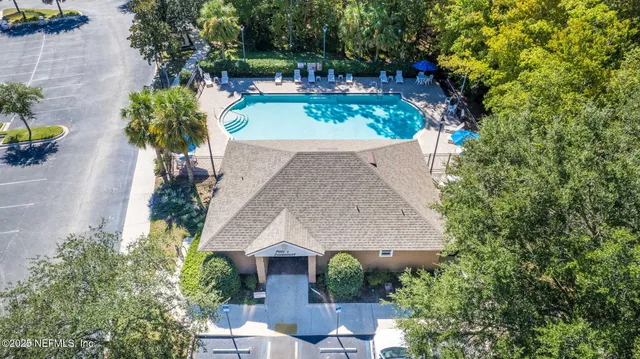an aerial view of residential houses with outdoor space and swimming pool