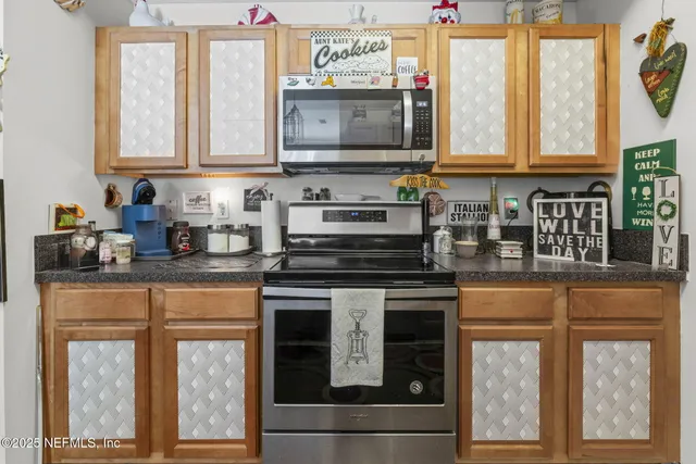 a kitchen with stainless steel appliances granite countertop a stove and a microwave