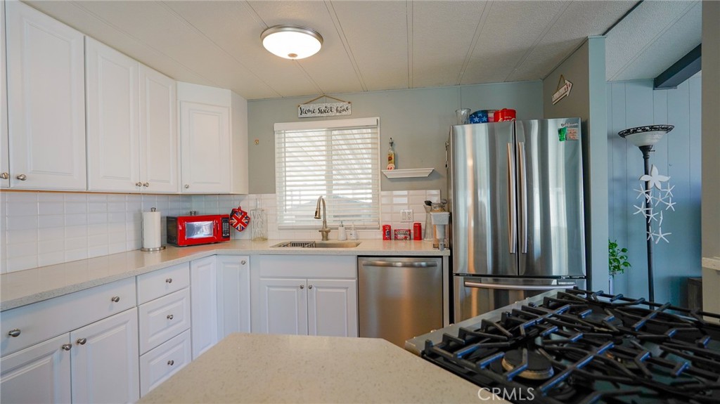 5200 Heil Avenue, Unit 18 Huntington Beach, CA 92649 - Photo 8 of 21 a kitchen with stainless steel appliances a sink stove and refrigerator
