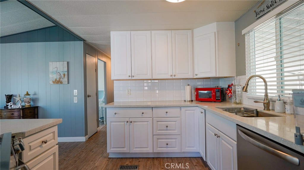 5200 Heil Avenue, Unit 18 Huntington Beach, CA 92649 - Photo 9 of 21 a kitchen with granite countertop white cabinets and stainless steel appliances