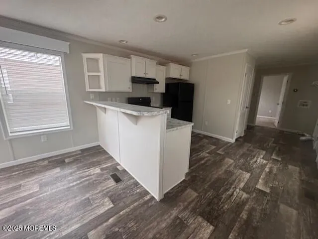 a kitchen with granite countertop a refrigerator and a stove top oven